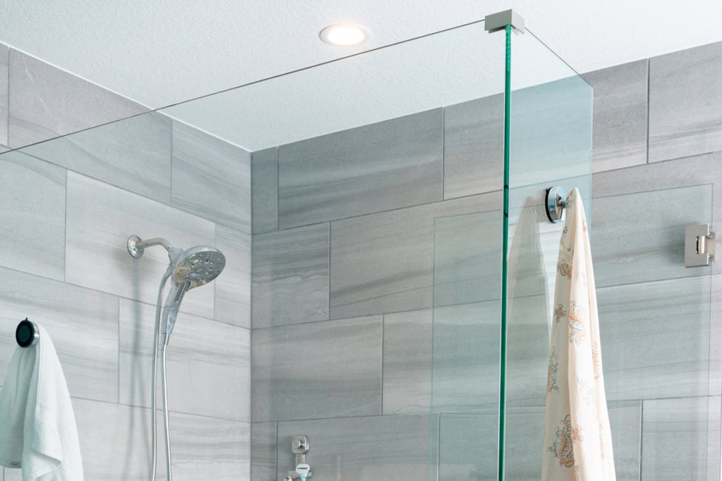 The remodeled shower creating a seamless material palette. Within the shower, this tile transitions to a smaller-scale mosaic for the pan, preserving the minimalist look while improving slip resistance.