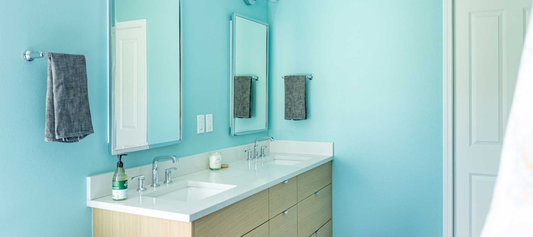 A light oak vanity introduces natural warmth, and a bold electric blue accent wall adds unexpected energy to the space.