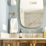 mirrored vanity with bronze hardware and walnut cabinets