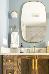 mirrored vanity with bronze hardware and walnut cabinets